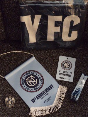 City Founding Members gift. Membership card, lanyard, 10 year pigeon pin, mini pre-match exchange banner, and lightweight scarf