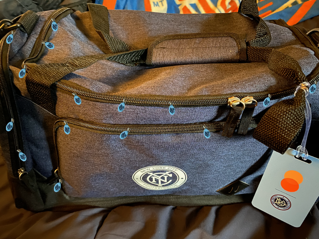 NYCFC bag with quite a large number of zipper pulls
